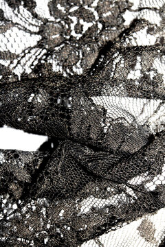 Close up of vintage black gothic lace fabric white on black background embroidery