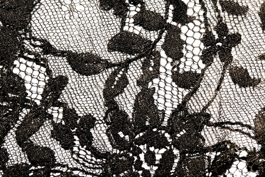 Close up of vintage black gothic lace fabric white on black background embroidery
