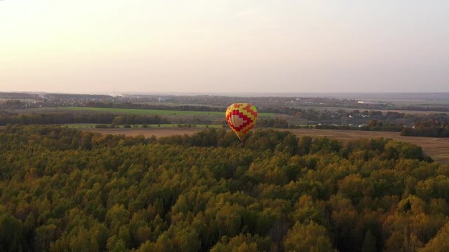 Flight hot air balloon in the countryside. Aerostat fly over over fields and forest.