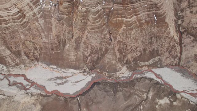 Abstract textures on the drained reservoir floor at Vidraru Dam with mineral patterns and sediment layers	
