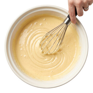 Whisking cake batter in a white ceramic bowl