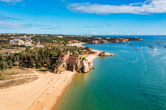 Ferragudo with the Praia Grande (the main beach) and the river Rio Arade, Algarve, Portugal. Beautiful seascape with beach, cave and ocean, Praia Grande beach, Ferragudo, Lagoa, Algarve, Portugal.