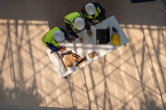 Construction planning meetings industrial setting professional discussion collaborative environment aerial view teamwork strategy