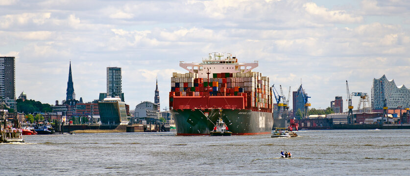 The Neo Panamax container ship GUAYAQUIL EXPRESS on the river Elbe leaving the port of Hamburg with the skyline of the town in the back, Germany
