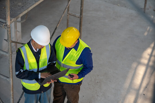 Construction workers collaborating on project construction site photo indoor overhead view teamwork and safety