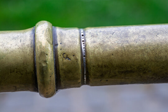 Macrophotographie d'un tuyau en laiton vintage avec patine naturelle.