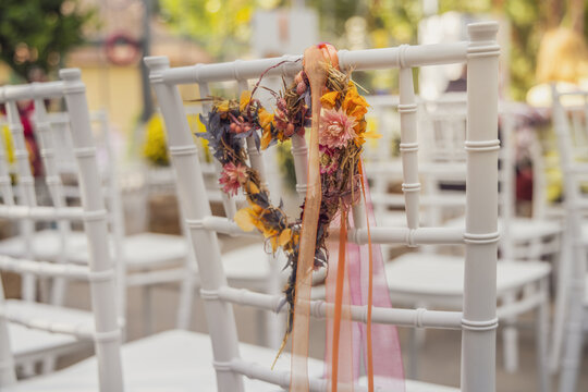 Flower wreath decorating white chairs