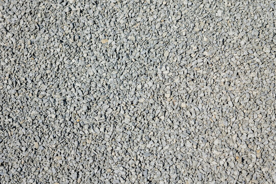 Fine gravel texture background, compacted stone surface used for base layer and construction, abstract pattern of small stones, ground material for building and landscaping
