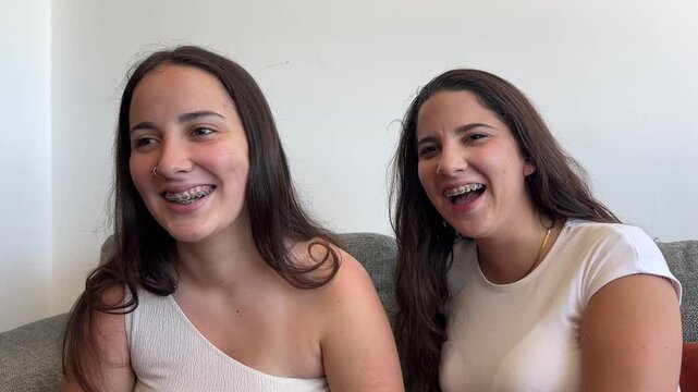 Alejamiento de dos chicas j&oacute;venes con brackets sonriendo