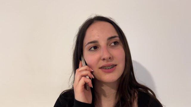 Primer plano de chica con brackets hablando por tel&eacute;fono