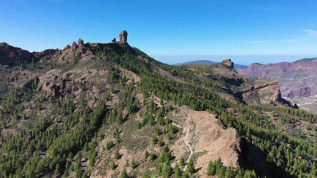Roque Nublo and Pico de Teide in the background on Gran Canaria Island, Spain. Panoramic view of Roque Nublo sacred mountain, Roque Nublo Rural Park, Gran Canary, Canary Islands, Spain.