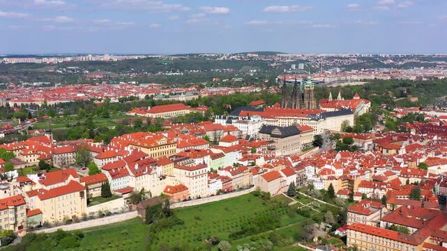 Panoramic view of Prague featuring historic castle and vibrant rooftops on a sunny day in summer. Aerial view of Prague, Czech Republic, showcasing the city's iconic architecture and red-tiled roofs.
