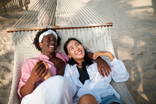 Carefree couple enjoying a tropical beach vacation, laughing making unforgettable memories together