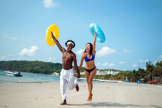 Beautiful diverse couple enjoying in good mood on the beach. Lifestyle love dating vacation concept