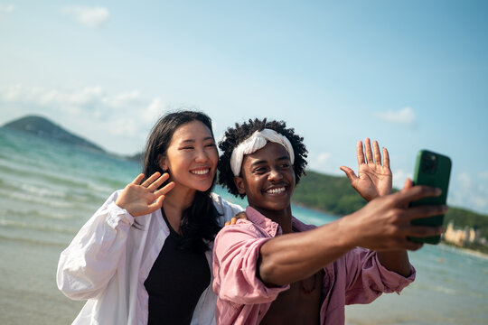Happy moments by the beach, friends enjoying mobile connection, social media, and summer vibes