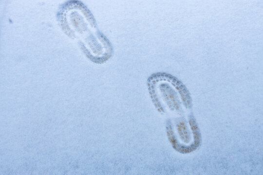 Two human footprints in the white snow