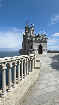 Swallow's nest castle perched on a cliff above the calm black sea, neo-gothic turreted landmark near yalta offering panoramic coastal views under a clear summer sky