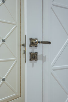 black door handle and light switch next to it in a bright room or office