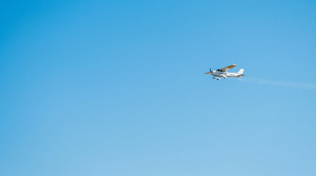 Avi&oacute;n peque&ntilde;o en cielo azul limpio con gran espacio negativo, composici&oacute;n minimalista ideal para publicidad.