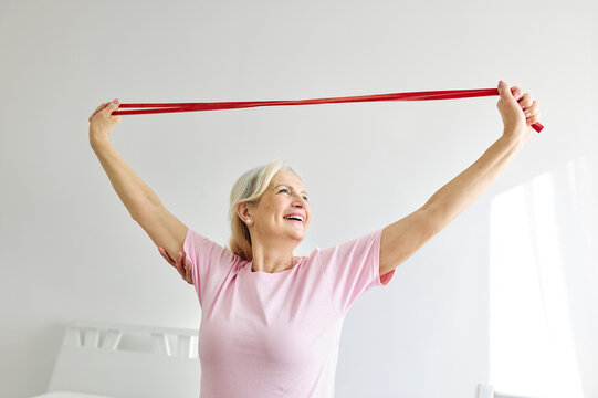 Senior woman exercise stretching band at home, health care and active seniors concept