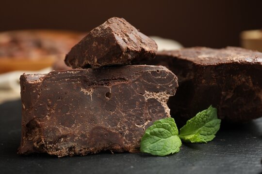 Natural chocolate chunks and mint on table, closeup
