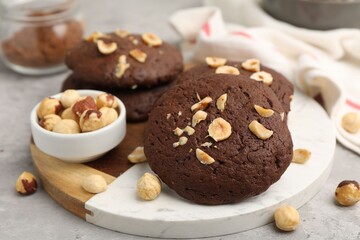 Fototapeta premium Tasty chocolate cookies with hazelnuts on grey table, closeup