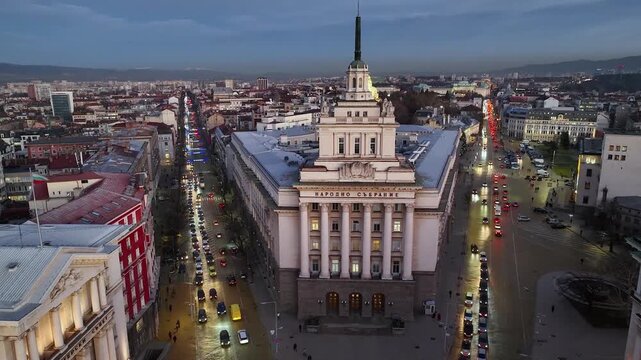 Aerial night view of capital of Bulgaria Sofia. Three architectural and iconic buildings of the communist era. Council of Ministers, Presidency and Party home Current Parliament building. Backward. 4K