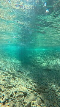 Transparent flowing river, underwater view in crystal water