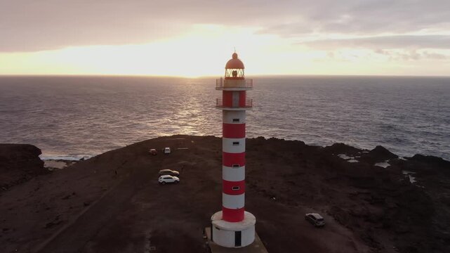 Stunning aerial footage showing the iconic Sardina del Norte lighthouse on the coast of Gran Canaria island during a beautiful sunset