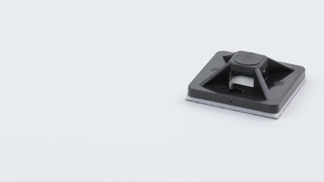 Plastic self-adhesive pad for installing nylon ties.