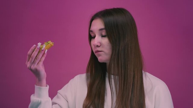 Teenage girl eating a sweet delicious cake, pastry. Teen woman savoring a dessert, taking a bite with appetite, enjoys food. Close-up lifestyle. Cream pie. Unhealthy food.