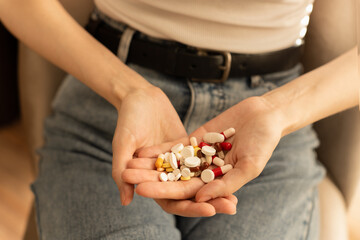 Obraz premium A person sits with his palm open and neatly lays out colorful pills. The focus is on health. The concept of healthcare and medicine.