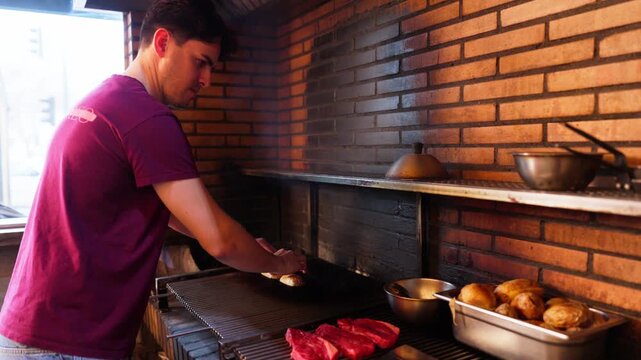 Professional chef cooking meat and potatoes on a grill
