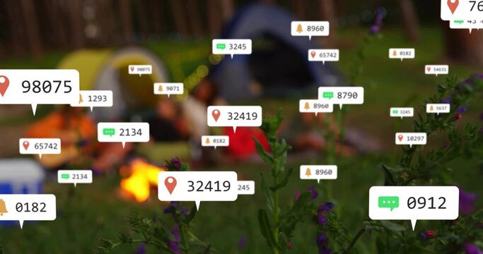 Highlighting flowers with label 32419 at dusk campsite, blurring campers wearing coats by campfire