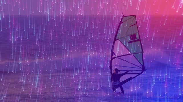 Male sports windsurfer shifting weight pulling boom to steady sail and balance under pink-blue rays
