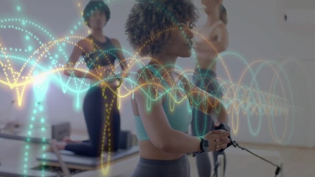 Camera framing woman holding straps and fitness class pulling for strength waveform tracking