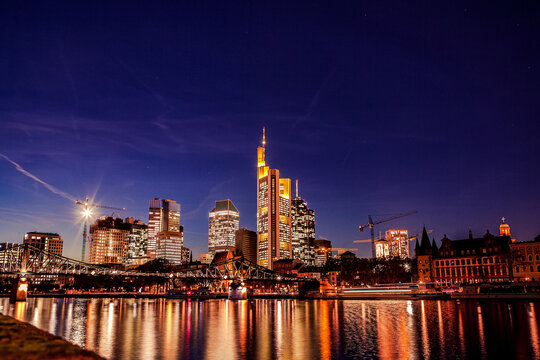 Frankfurt city skyline glowing at night over main river