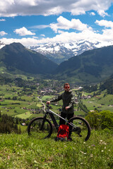 Obraz premium Man standing with mountain bike on a scenic hill