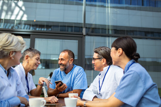 Doctors and nurses sharing coffee break outside hospital
