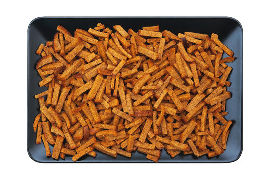 Pile of fried croutons on a dark rectangular tray, top view against a transparent background. PNG.