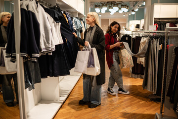 Fototapeta premium Young women shopping for clothes in retail store