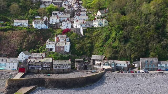 Aerial view of Clovelly Village and Harbour which is a historic 13th-century stone quay located in a privately owned, picturesque North Devon fishing village. Scenic Drone Exploration of village.