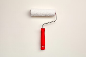 Obraz premium White Paint Roller on a Clean Surface With Red Handle Ready for Use in a Home Improvement Project