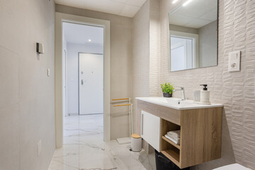 Fototapeta premium Modern minimalist bathroom with wooden vanity, mirror and bright clean interior leading to hallway