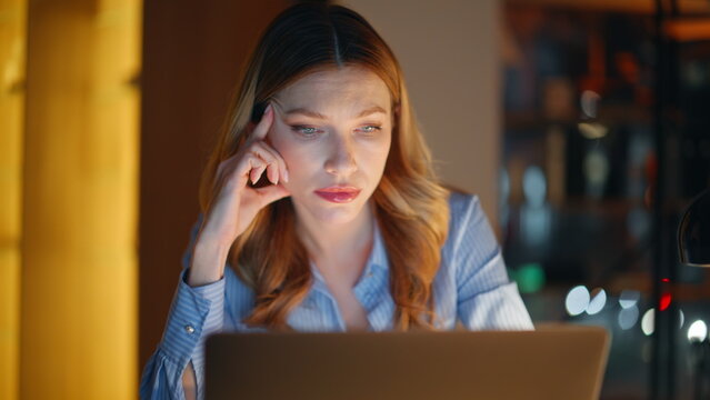 Employee working late evening browsing laptop closeup. Overworked businesswoman