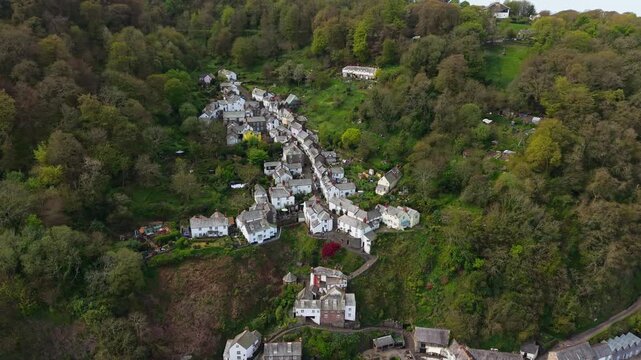 Aerial view of Clovelly Village and Harbour which is a historic 13th-century stone quay located in a privately owned, picturesque North Devon fishing village. Scenic Drone Exploration of village.
