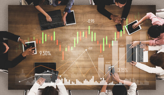 A diverse group of professionals engaged in financial analysis in a modern office. They use various devices and data visualizations to discuss market trends and strategies. Scalp