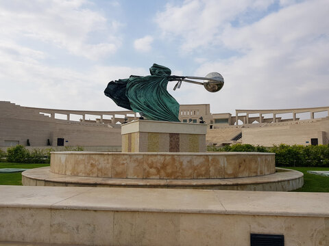 Doha, Qatar - April 2023: "Force of Nature II" sculpture at Katara Cultural Village, depicting a female figure swirling a globe, symbolizing the power of nature.