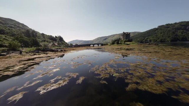 Cinematic Low Angle Drone Sot Over Calm Lake with Seaeed and Distant Castle