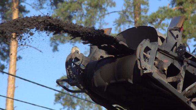 Conveyor Belt Discharging Asphalt Millings During Road Construction